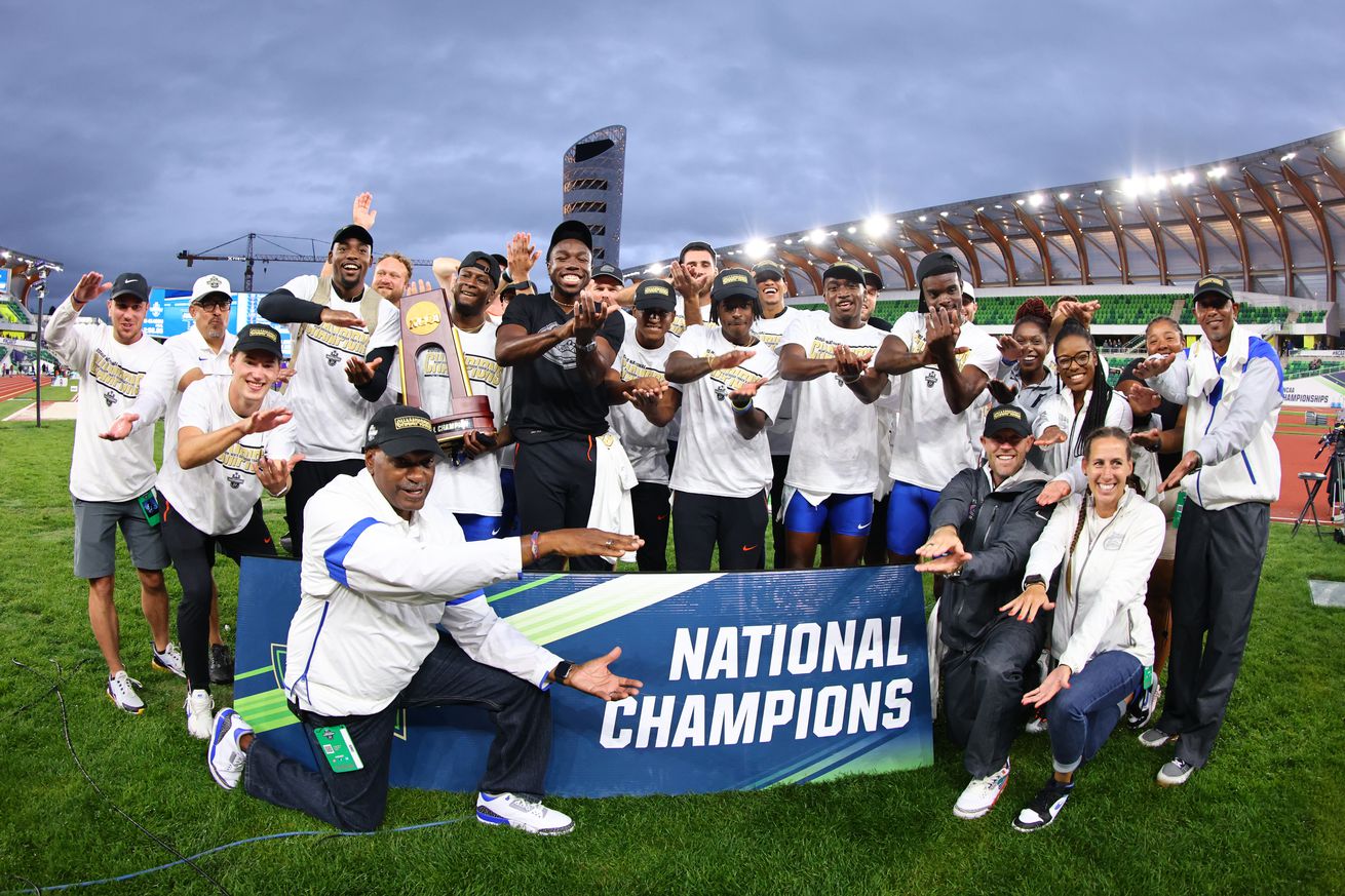 The Florida Gator’s celebrate winning the mens national title at the D1 Men’s and Women’s Outdoor Track and Field Championships by posing around a banner that says National Champions