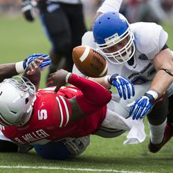 Ohio State Buckeyes quarterback Braxton Miller (5) loses the ball as he is tackled by Buffalo Bulls linebacker Khalil Mack (46) and linebacker Blake Bean (33) at Ohio Stadium. The play was nullified on a Buffalo Bulls penalty.Ohio State won the game 40-20
