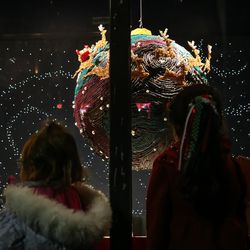 People peer through the windows at candy ornaments during an unveiling celebration for the Macy's holiday candy windows at the City Creek Center in Salt Lake City on Thursday, Nov. 17, 2016.