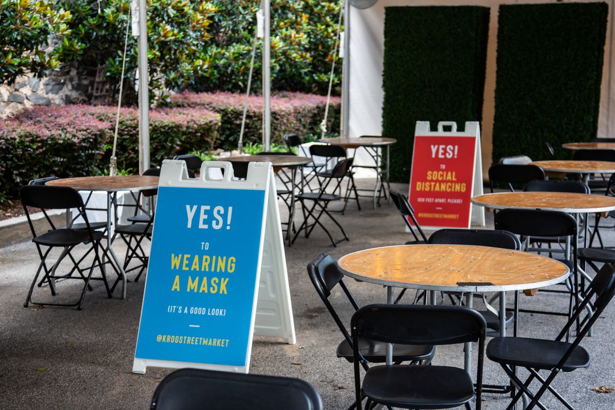 Blue and red placard signs posted outside of Krog Street Market in Atlanta stating, “Yes to wearing a Mask” inside in June 2020