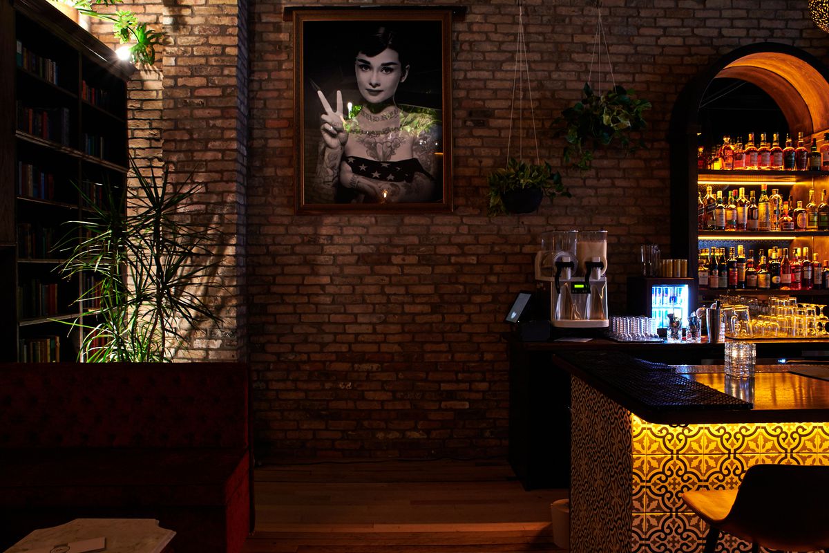 The portrait of Audrey Hepburn at Two Wrongs features the actress holding up two fingers. It sits next to the bar’s slushie machine