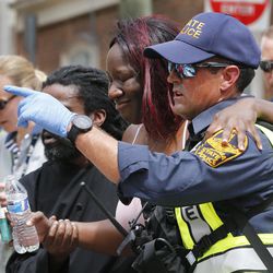 Rescue personnel help an injured woman after a car ran into a large group of protesters after an white nationalist rally in Charlottesville, Va., Saturday, Aug. 12, 2017.  The nationalists were holding the rally to protest plans by the city of Charlottesville to remove a statue of Confederate Gen. Robert E. Lee. There were several hundred protesters marching in a long line when the car drove into a group of them. 