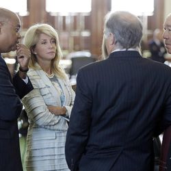 Sen. Wendy Davis, D-Fort Worth, second from left, talks with Sen. Rodney Ellis, left, Sen Juan "Chuy" Hinojosa, D-McAllen, right, and Kirk Watson, D-Austin. as she prepares to filibusters an abortion bill, Tuesday, June 25, 2013, in Austin, Texas. The bill would ban abortion after 20 weeks of pregnancy and force many clinics that perform the procedure to upgrade their facilities and be classified as ambulatory surgical centers. (AP Photo/Eric Gay)