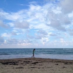 In this October 2014 photo, a woman walks along Isla Verde Beach in San Juan, Puerto Rico. Puerto Rico, a U.S. territory, offers all the comforts of domestic travel - easy entry, no extra charges for cell phone service, and the U.S. dollar as the currency - along with Caribbean beaches and Latin culture, waterfalls, colonial Spanish history and good food and drink. 