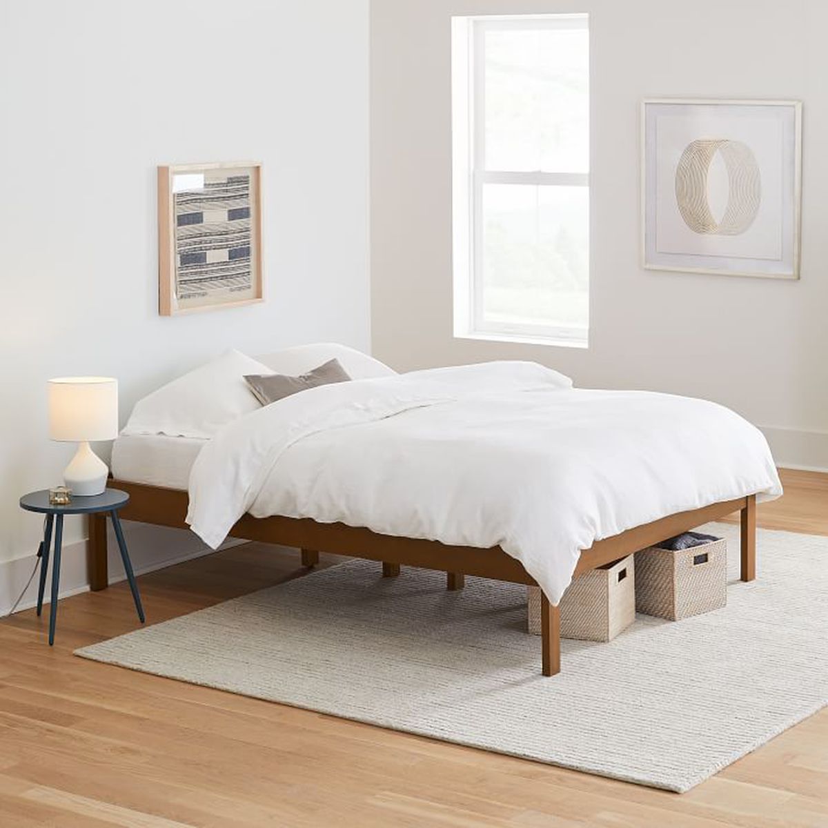 A simple, wooden bedframe with four legs. 