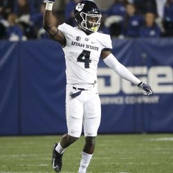 Utah State Aggies safety Aaron Wade (4) holds up his hand in celebration after the Aggies picked off a pass and ran it back for a touchdown during the Utah State versus BYU football game at LaVell Edwards Stadium in Provo on Friday, Oct. 5, 2018.