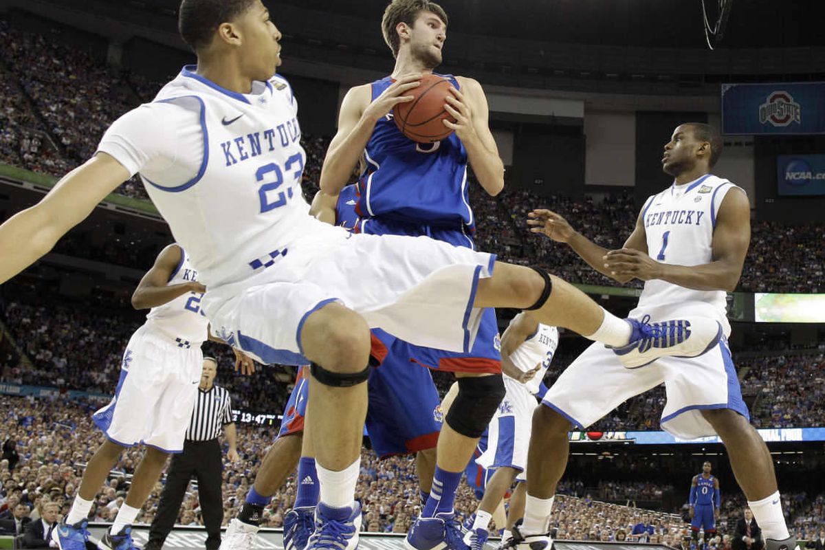 Kansas' Jeff Withey, center, grabs a rebound between Kentucky's Anthony Davis, left, and Darius Miller, right, during the first half of the NCAA Final Four tournament college basketball championship game Monday, April 2, 2012, in New Orleans. (AP Photo/Da