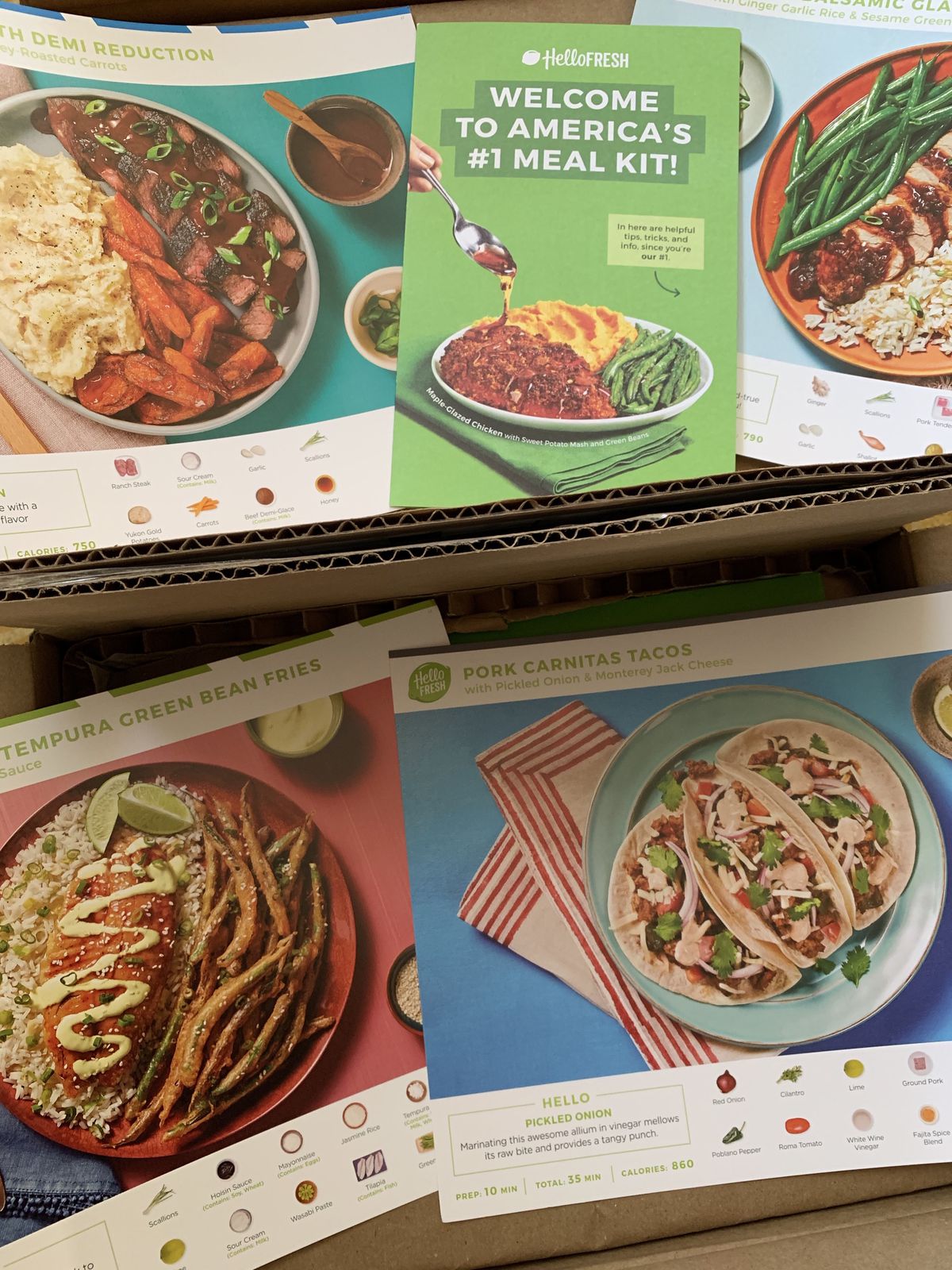 From above, two cardboard boxes filled with colorful recipe cards and advertisements 