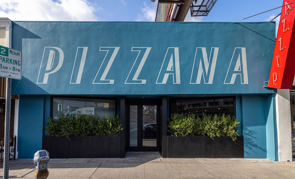 A wide look at the blue front of a new pizza restaurant.