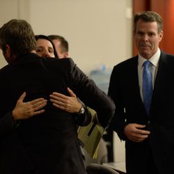 Defense attorney's Cara Tangaro and Scott C. Williams embrace as former Utah Attorney General John Swallow, right, looks on at the Matheson Courthouse in Salt Lake City on Thursday March 2, 2017. A jury found Swallow not guilty on all charges in his public corruption trial.