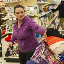 Shannon Cox puts a stuffed animal into her cart while doing last-minute shopping at Target in Salt Lake City on Friday, Dec. 23, 2016. Cox was shopping for her organization, Journey of Hope, which helps incarcerated women provide gifts for their children during the holiday season.