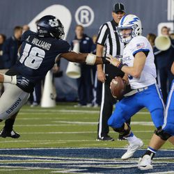 Air Force quarterback Nate Romine (center) tries to get away from Utah State Aggies linebacker Anthony Williams (left) during the third quarter at Merlin Olsen Field at Maverik Stadium.