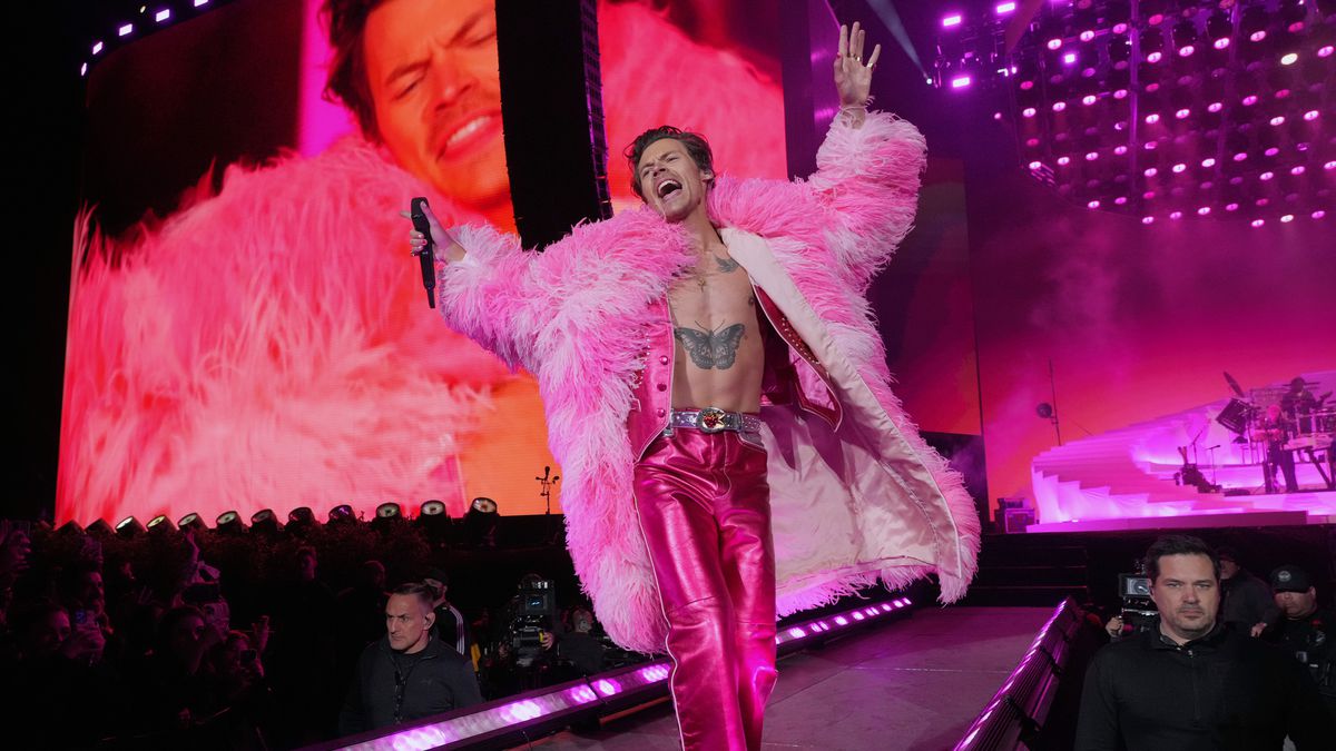 A person in a pink fur coat and pink pants on a stage.