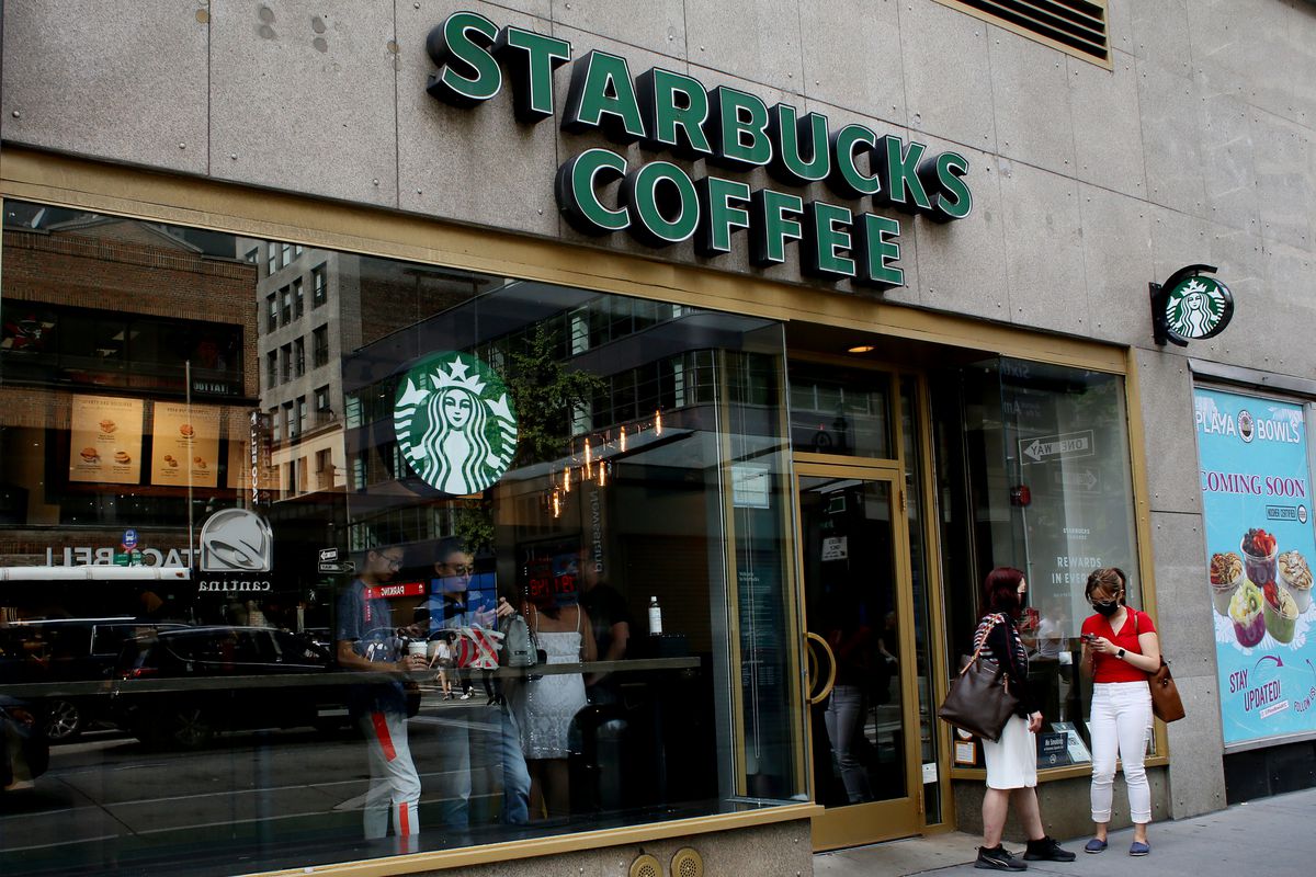The exterior of a Starbucks store as seen from the sidewalk.