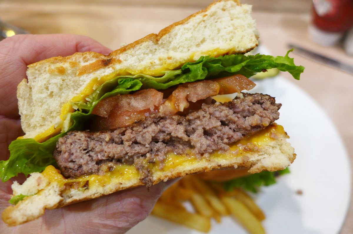 A cut burger showing the gray crumbly meat inside.