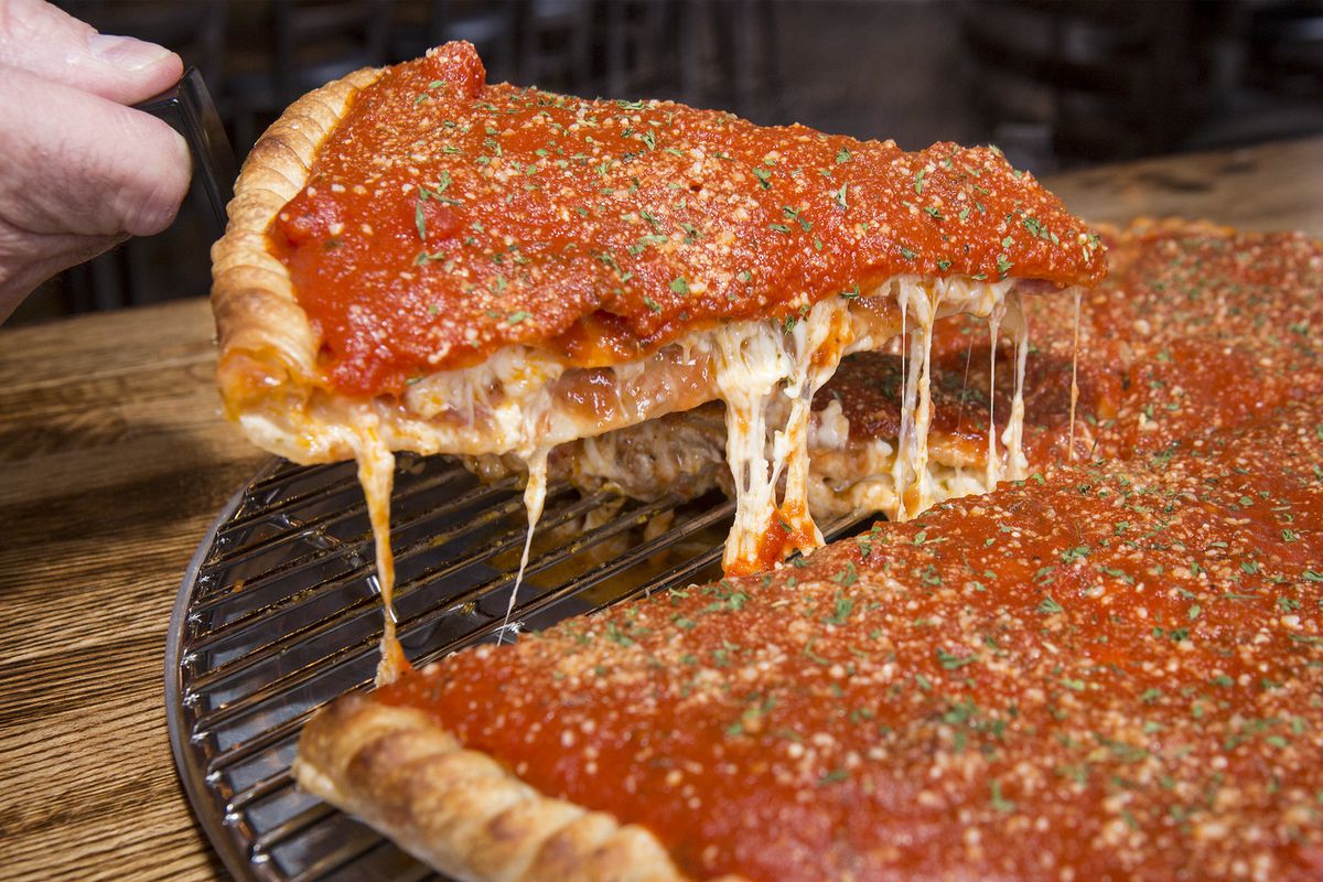 A slice of Chicago stuffed pizza cut from a whole pie.
