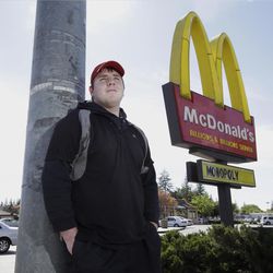 In this photo take Tuesday, March 29, 2016, Nathan Howard, 20, poses outside the suburban McDonalds that he works at in Rancho Cordova, Calif. California state lawmakers are expected to vote, Thursday, on a proposal to gradually raise California's minimum wage to a nation leading $15 an hour by 2022. Howard, who said he makes $10.25 an hour, says he would benefit from the raise, but opponents of the bill say it will further harm California's already poor business climate. 