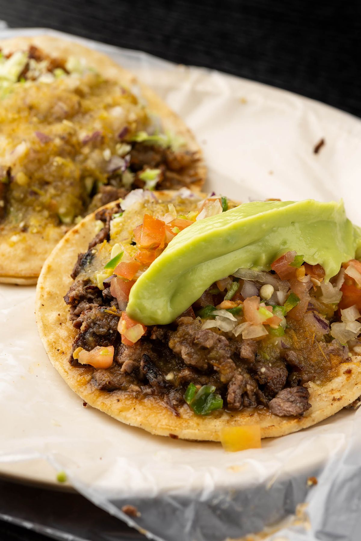 An guacamole-topped grilled beef taco.