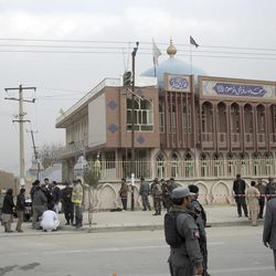 Afghan security forces and civilians walk around the Shiite Baqir-ul Ulom mosque after a suicide attack inside it, in Kabul, Afghanistan, Monday, Nov. 21, 2016. An Afghan official says that dozens of civilians have been killed after a suicide bomber attacked a Shiite mosque in the capital. 