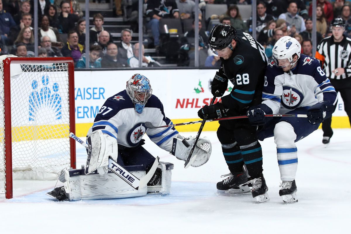 Dec 20, 2018; San Jose, CA, USA; San Jose Sharks right wing Timo Meier (28) attempts to play a rebound past Winnipeg Jets goaltender Connor Hellebuyck (37) while being pressured by defenseman Jacob Trouba (8) during the second period at SAP Center at San 