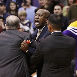 L.A. Lakers coach Mike Brown is restrained as he screams at the officials after being ejected for bumping a referee in Saturday's game.    