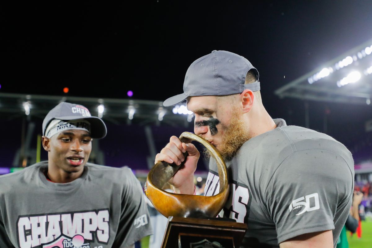 Stephen Calvert #12 of the Liberty Flames celebrates with the Trophy after defeating the Georgia Southern Eagles in the 2019 Cure Bowl at Exploria Stadium on December 21, 2019 in Orlando, Florida.