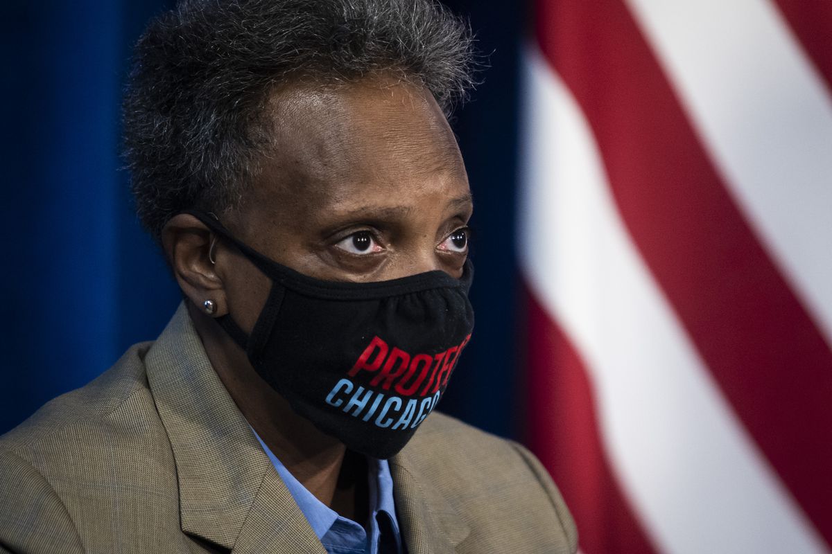 Mayor Lori Lightfoot wears a face mask as she listens to Dr. Allison Arwady, commissioner of the Chicago Department of Public Health, discuss Chicago’s COVID-19 response during a news conference Sunday morning at City Hall in the Loop.