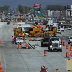 FILE — Traffic moves past construction workers and equipment for the Point Project on I-15 near Point of the Mountain on Tuesday, April 12, 2016.