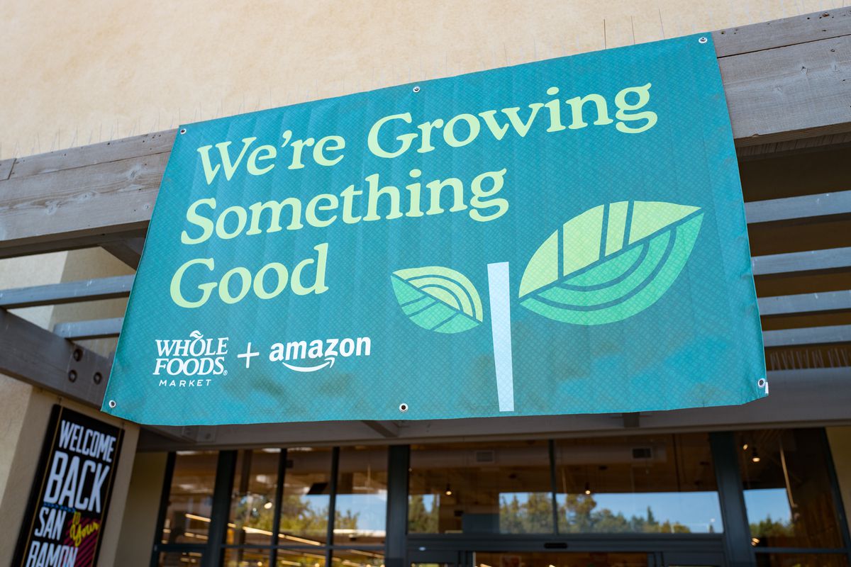 Signage announcing Whole Foods acquisition by Amazon