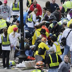 Medical workers aid injured people at the finish line of the 2013 Boston Marathon following an explosion in Boston, Monday, April 15, 2013. Two explosions shattered the euphoria of the Boston Marathon finish line on Monday, sending authorities out on the course to carry off the injured while the stragglers were rerouted away from the smoking site of the blasts. 
