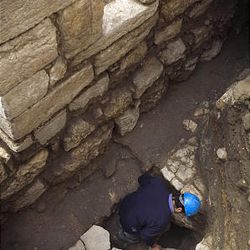 A worker cleans a stone in a 1,500-year-old street located 4.3 meters (14 feet) below ground level, revealed by the Israeli Antiquities Authority in the old city of Jerusalem, Wednesday.