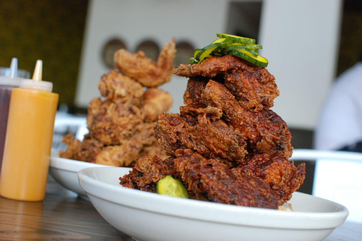 Two plates with towers of Tennessee hot and Southern fried chicken