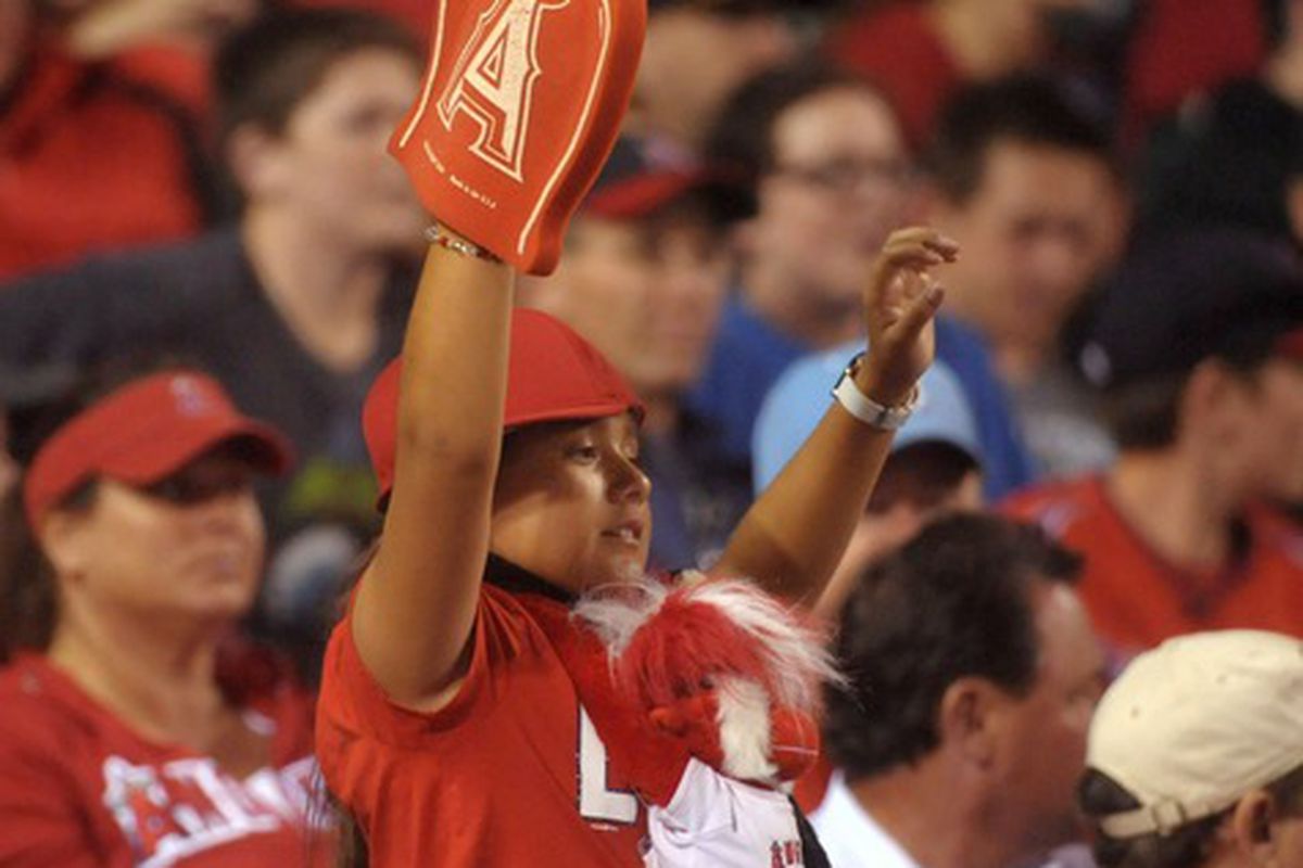 May 28, 2012; Anaheim, CA, USA; A fan of the Los Angeles Angels holds a foam finger and wears a rally monkey around her neck during the game against the New York Yankees at Angel Stadium. Mandatory Credit: Kirby Lee/Image of Sport-US PRESSWIRE