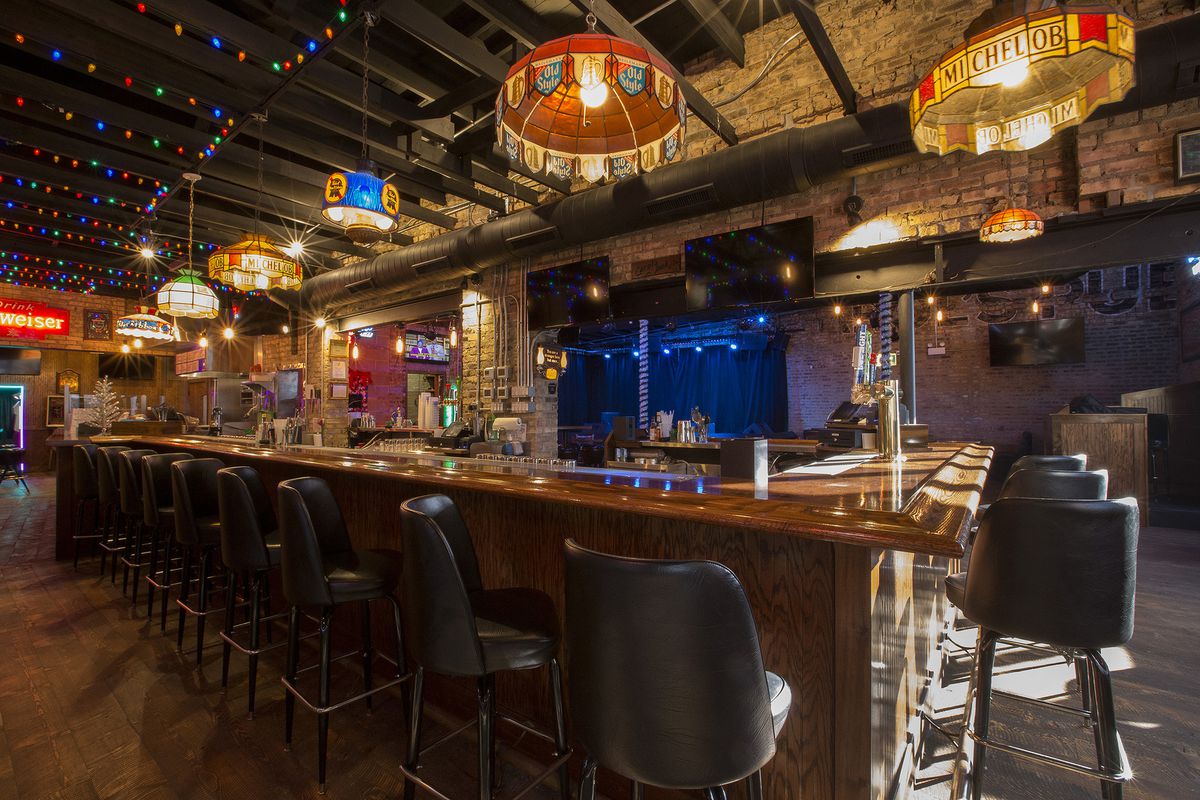 Carol’s Pub’s interior features hanging lights, black bar stools, a brand new bar, and a musical stage