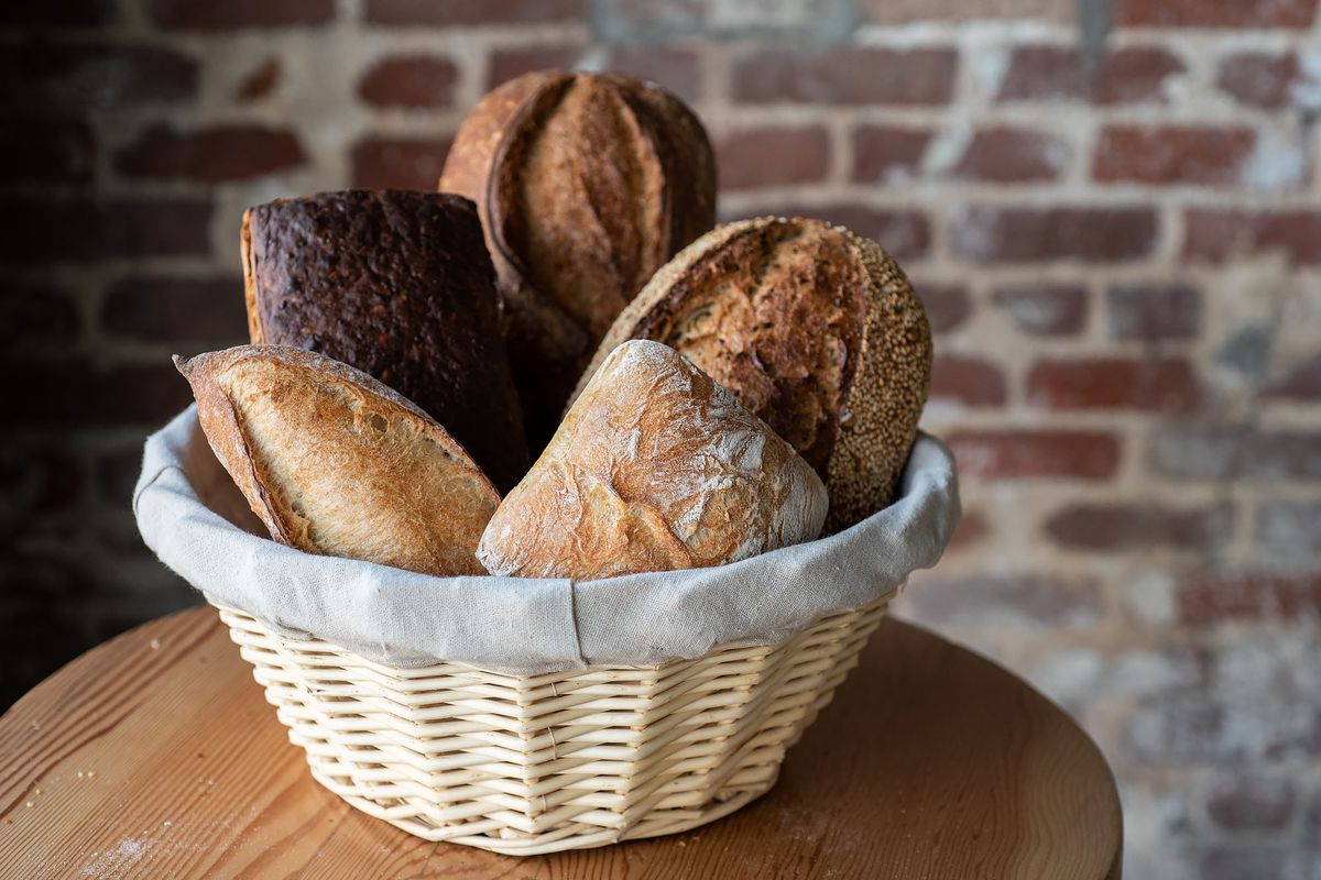 A basket of freshly baked breads on varying sizes.