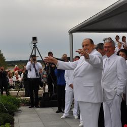 LDS Church President Thomas S. Monson pretends to lead the music as the choir sings at the close of the cornerstone ceremony at the Kyiv Ukraine Temple dedication services Sunday, Aug. 28, 2010, in Kiev, Ukraine.. Also watching are President Dieter F. Uchtdorf, second counselor in the First Presidency, and Elder Russell M. Nelson of the Quorum of the Twelve Apostles.