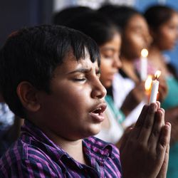 Indian students  hold a candles and pray for the victims of Uttarakhand floods, in Jammu, India, Friday, June 21, 2013. The Indian air force is dropping paratroopers, food packets and medicine for tens of thousands of people trapped in up to 100 inaccessible towns and villages in northern Himalayas devastated by heavy monsoon rains and landslides over the weekend and more than hundred people are killed. 