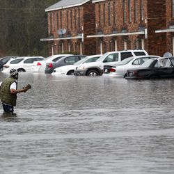 A man wades through flood waters in Hammond, La., Friday, March 11, 2016. Torrential rains pounded northern Louisiana for fourth day Friday, trapping several hundred people in their homes, leaving scores of roads impassable and causing widespread flooding.