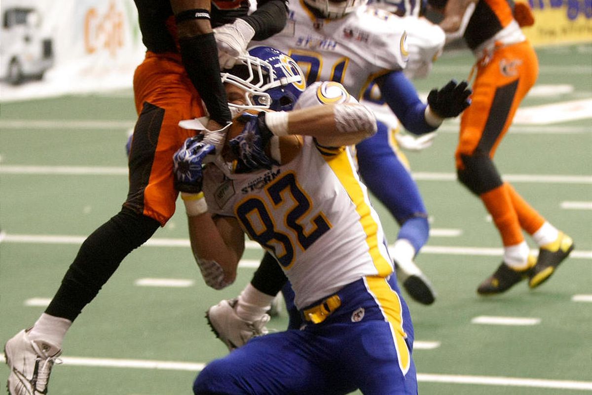 The Utah Blaze's Maurice Leggett and the Tampa Bay Storm's Greg Ellingson reach for the ball during an indoor football game at EnergySolutions Arena in Salt Lake City on Saturday, April 6, 2013.