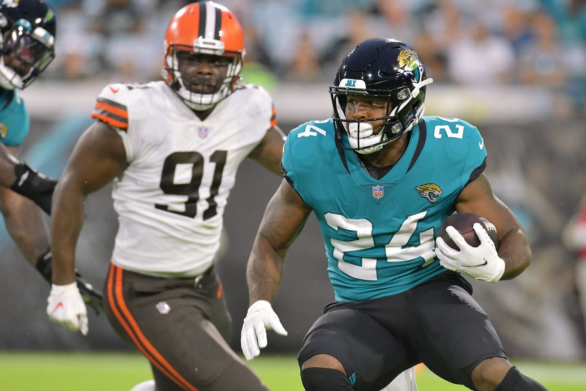 Jacksonville Jaguars running back Carlos Hyde (24) looks for running room on a handoff play from Jacksonville Jaguars quarterback Gardner Minshew (15) during second quarter action. The Jacksonville Jaguars hosted the Cleveland Browns for their only home preseason game at TIAA Bank Field in Jacksonville, Florida Saturday night, August 14, 2021.&nbsp;