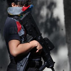 An armed and masked federal police officer stands guard as part of increased security outside the SEIDO, the organized-crime division of Mexico's Attorney General Office where high profile detainees are sometimes shown to the press in Mexico City, Friday, Feb. 27, 2015. The leader of the Knights Templar cartel, Servando "La Tuta" Gomez," one of Mexico's most-wanted drug lords, was captured early Friday by federal police in the capital city of Morelia, according to a Mexican official. It could not be confirmed if Gomez was inside the building. 