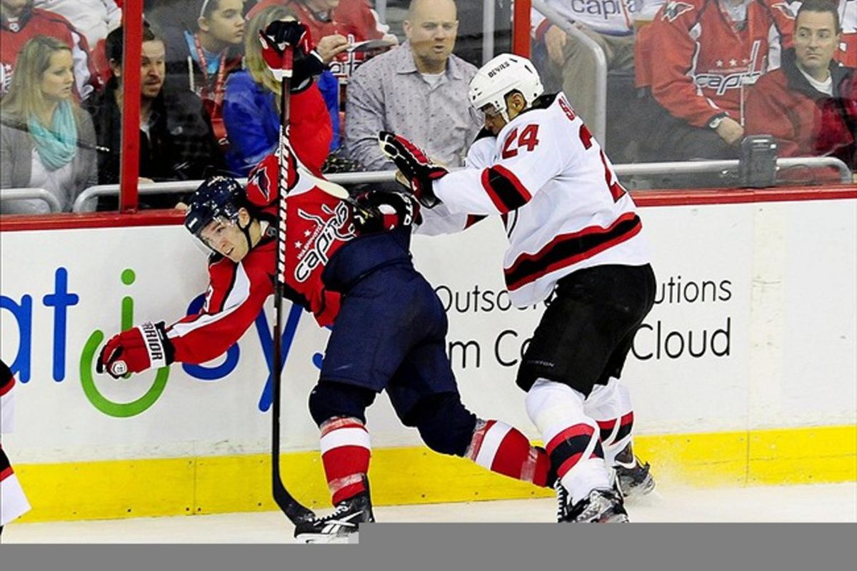 March 2, 2012;Washington D.C., USA; Washington Capitals right wing Keith Aucoin (23) is checked into the boards by New Jersey Devils defenseman Bryce Salvador (24) at Verizon Center. Mandatory Credit: Evan Habeeb-US PRESSWIRE