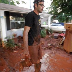 Jason Hurst helps his friend Lyle Hurd clean out his home after flood waters pushed into the home. Thousands of volunteers swarm to help residents in Santa Clara work to clean up after flood waters broke the dike Tuesday, Sept. 11, 2012 and destroyed several homes and businesses. 