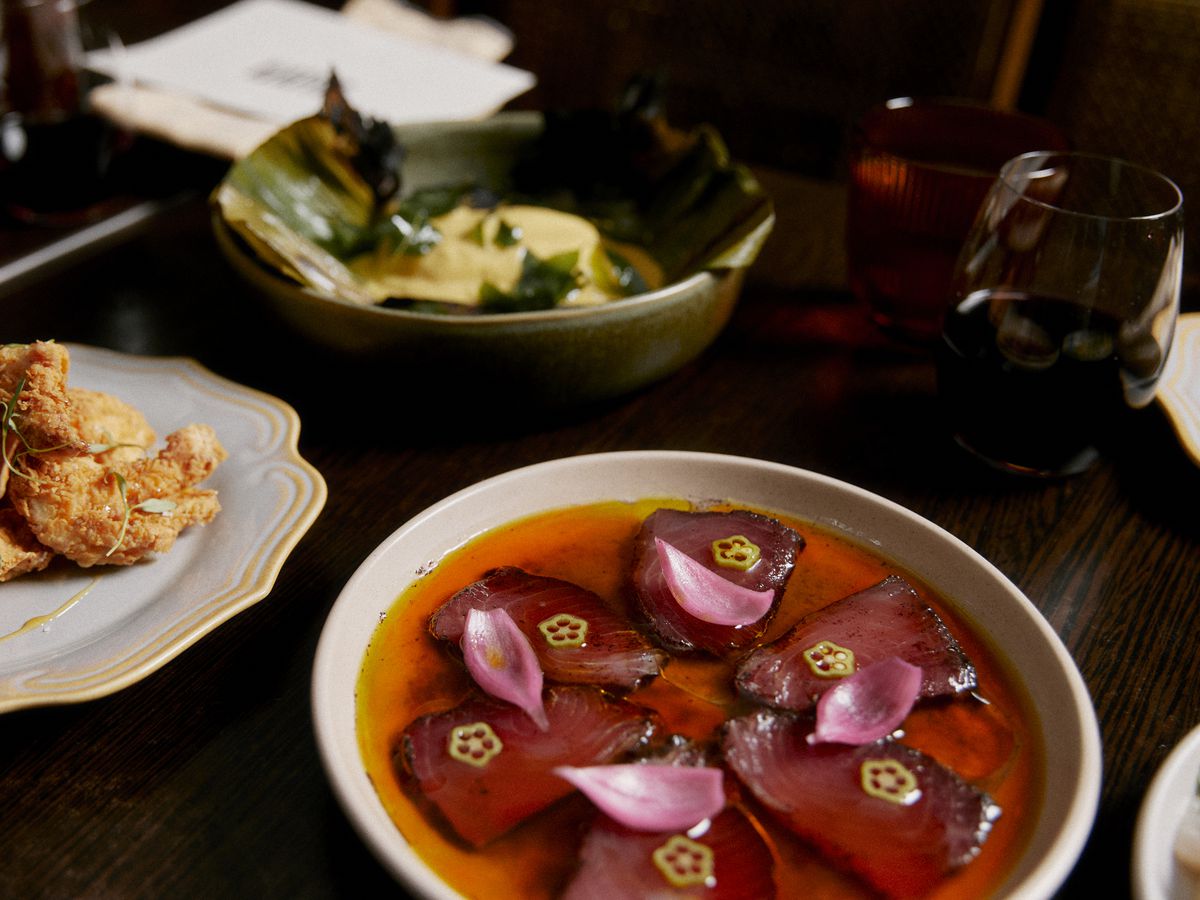 A few bright dishes, including slices of sashimi in a deep red sauce. 