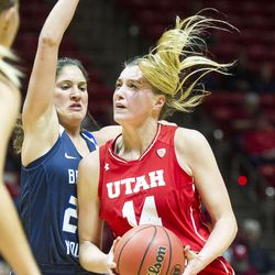Utah guard Paige Crozon (14) drives against Brigham Young guard Cassie Broadhead (20) during an NCAA women's college basketball game in Salt Lake City on Saturday, Dec. 10, 2016. Utah defeated rival Brigham Young 77-60.