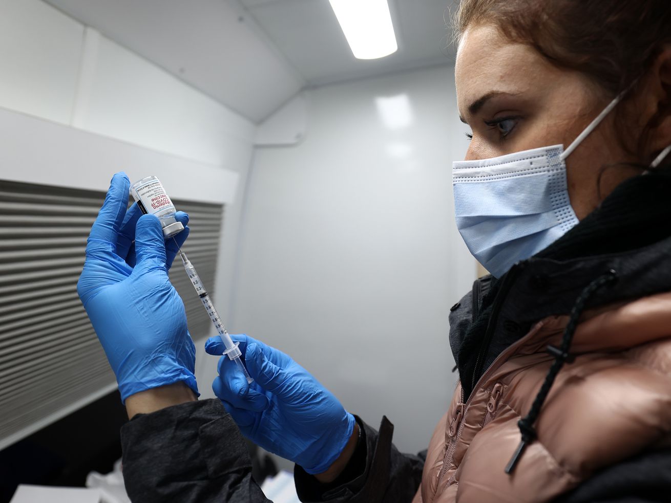 Christine Spencer fills a syringe with the Moderna COVID-19 vaccine at a Salt Lake County Health Department mobile site at Tejeda’s Market in Salt Lake City on Wednesday, Dec. 29, 2021.