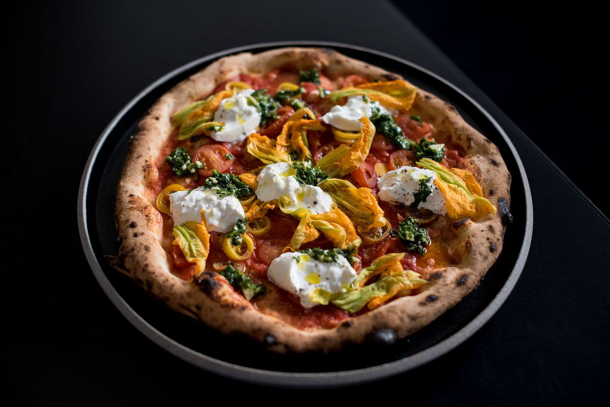 A whole pizza from Pizzana, with burrata and squash blossoms.