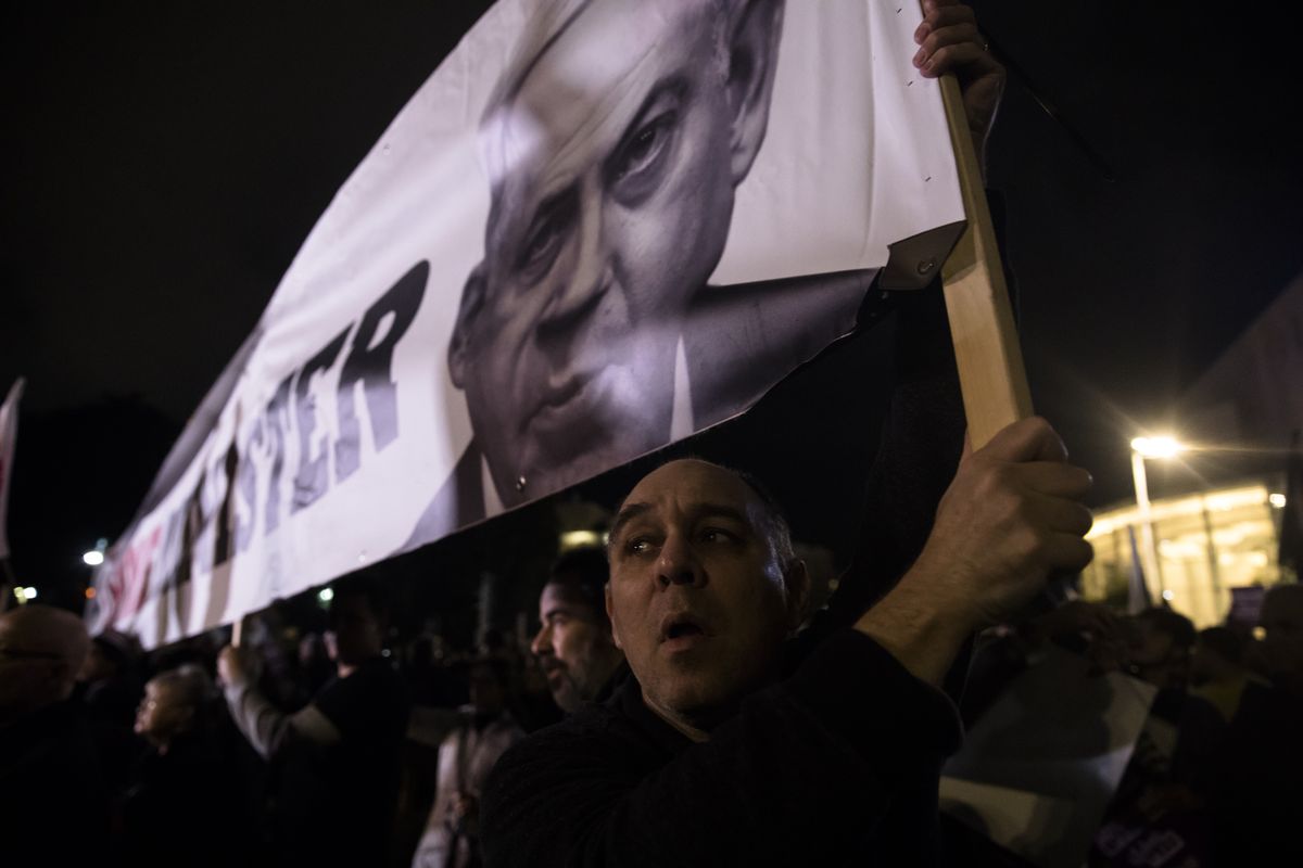 A protester holds a placard with a photo of Israeli Prime Minister Benjamin Netanyahu as he protests against the Israeli government’s plan for dramatic justice reform on January 8, 2023, in Tel Aviv, Israel.&nbsp;