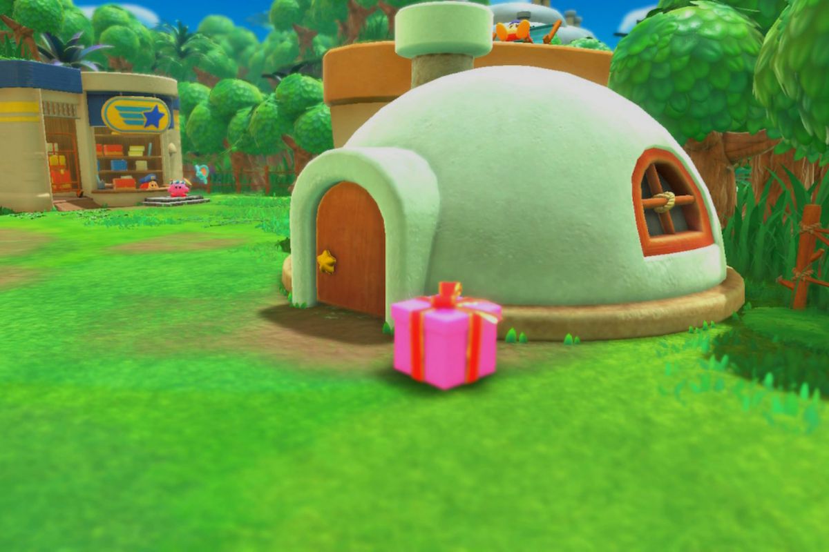 A pink gift sits in front of Kirby’s house in Waddle Dee Town