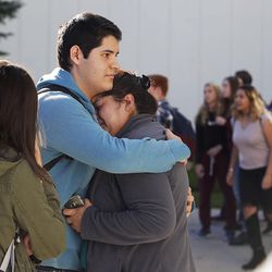 A family hugs as they reunite outside Mountain View High School in Orem on Tuesday, Nov. 15, 2016, after five students were stabbed in an apparent attack by a 16-year-old boy.